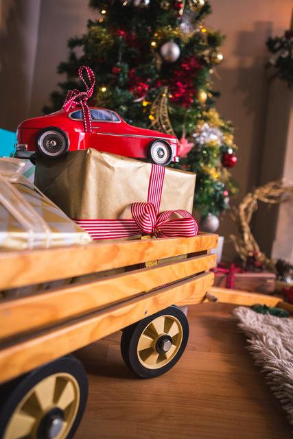 Close-up of Christmas gifts under a decorated tree, featuring a toy car on top of wrapped presents with red and white ribbon. Ideal for holiday-themed promotions, festive greeting cards, and Christmas advertisements.