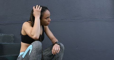 Exhausted woman resting after urban workout