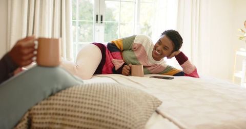 Friends Enjoy Relaxing Coffee Time in Cozy Bedroom