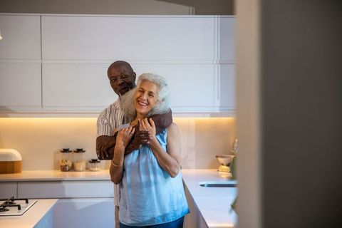 Senior couple embracing in modern kitchen