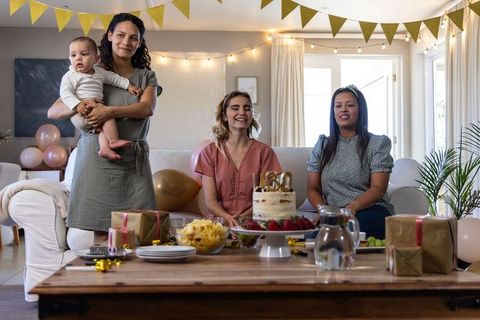 Diverse Women Celebrating Child's Birthday with Cake at Home