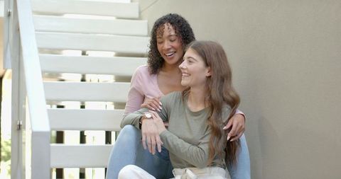 Happy Diverse Female Couple Laughing on Staircase