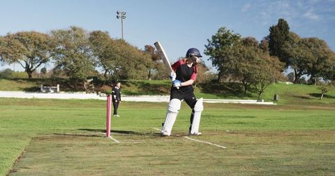 Female Cricketer Batting on Sunny Day in Park