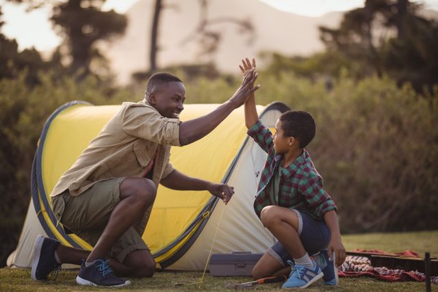 Father and Son High-Fiving While Camping Outdoors - Download Free Stock Photos Pikwizard.com