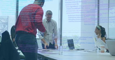Cross-functional team collaborating on software planning around meeting table with code overlay