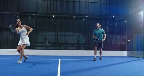 Energetic Padel Team on Blue Court Displaying Skillful Play