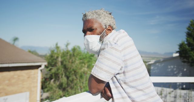 Senior man wearing face mask standing on balcony - Download Free Stock Images Pikwizard.com