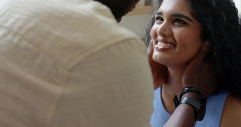 Couple sharing tender moment cradling face, woman smiling in intimate closeup