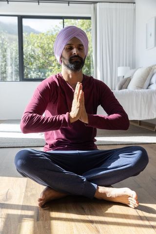 Indian Man Practicing Meditation in Bright and Tranquil Bedroom