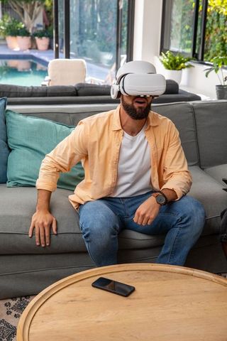 Man experiencing virtual reality on sofa in modern living space