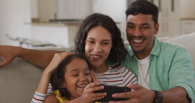 Happy Family Enjoying Time Together on Couch with Smartphone - Download Free Stock Images Pikwizard.com