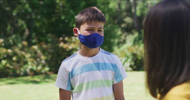 Young Boy in Striped Shirt Wearing Face Mask Outdoors - Download Free Stock Images Pikwizard.com