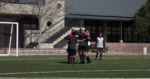 Soccer Team Celebrating Victory on Outdoor Field