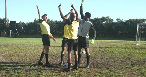 Team of Young Male Soccer Players Celebrating Victory on Field