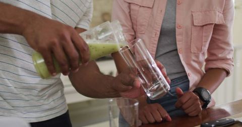 Bicultural couple enjoys healthy smoothie in modern kitchen