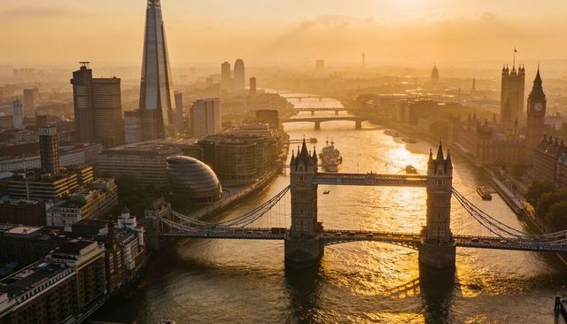 Golden hour over london river thames with tower bridge and shard aerial skyline sunset glow