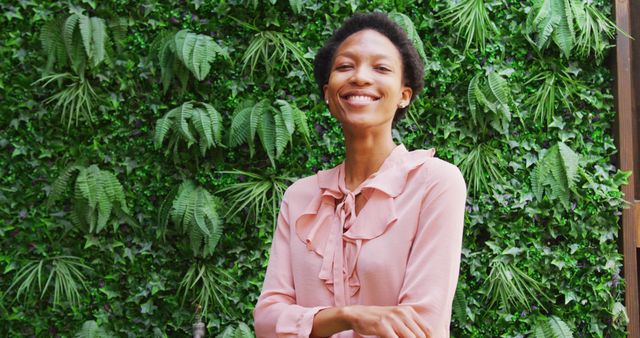 Confident Woman Smiling in Front of Leafy Green Wall - Download Free Stock Images Pikwizard.com