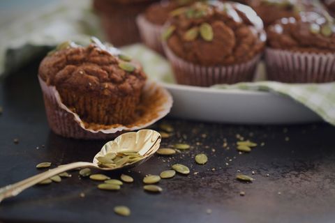 Freshly baked pumpkin seed muffins on dark background