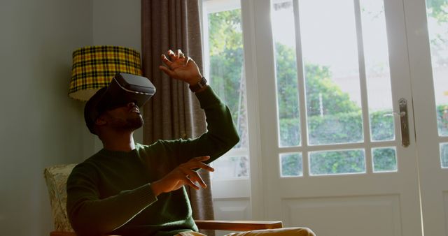 Man Sitting Indoors Using VR Headset in Virtual Reality Experience - Download Free Stock Images Pikwizard.com