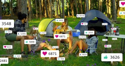 Playing acoustic guitar and chatting around campfire with floating social media reactions
