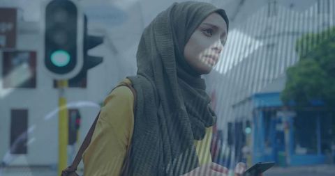 Young Woman in Hijab at Urban Intersection Using Smartphone