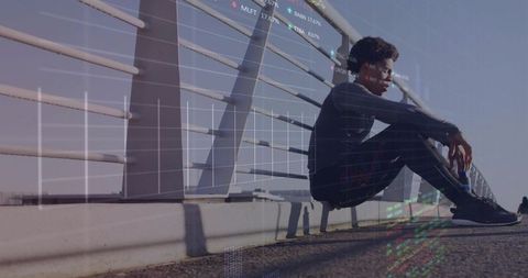 Contemplating urban investor leaning on bridge railing with stock market data overlay