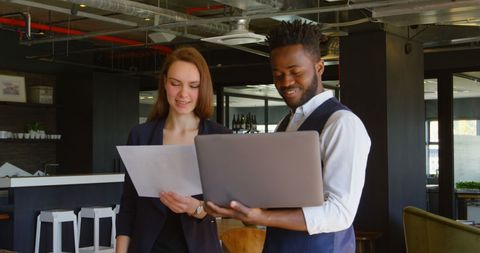 Smiling Colleagues Reviewing Documents in Modern Office