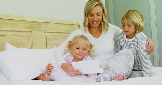 Mother Reading Tablet with Two Children in Bed - Download Free Stock Images Pikwizard.com