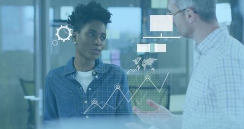 Business colleagues discussing analytics dashboard on glass partition with data overlay