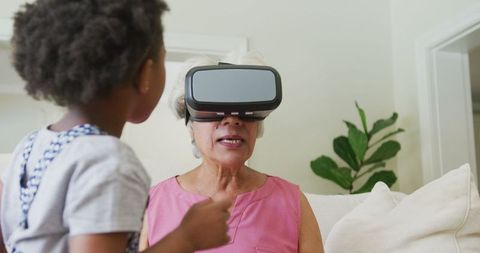 Grandmother Using VR Headset with Curious Granddaughter