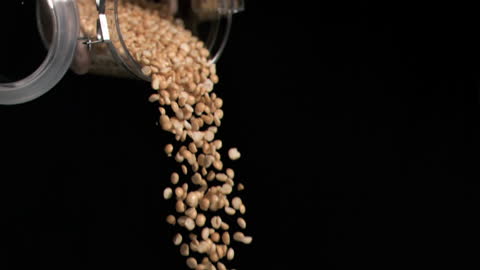 Peanuts Cascading from Glass Jar in Slow Motion