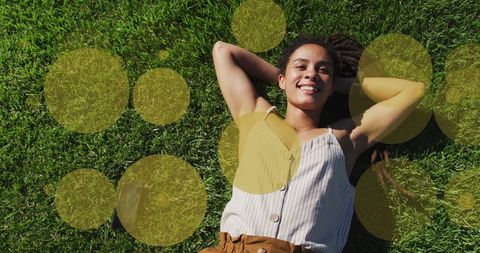 Smiling Woman Relaxing on Grass with Playful Yellow Circle Overlay