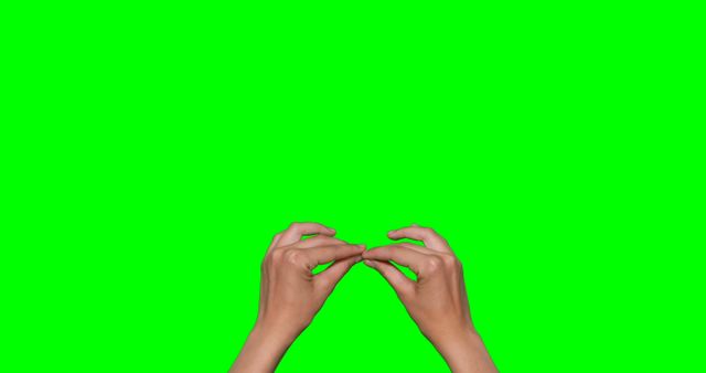 Hands making symbol against green screen