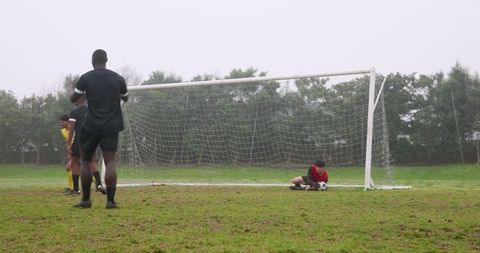 Diverse Soccer Players Guarding Goal on Misty Day