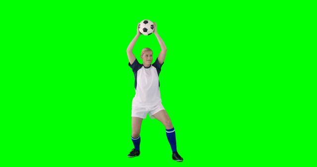 Front view of sportswoman is playing football against a green screen 