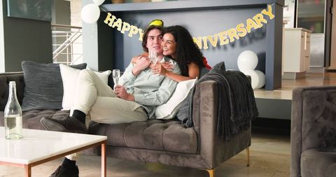 Happy Couple Celebrating Anniversary at Home with Champagne