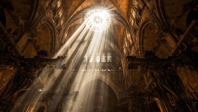 Sunbeams streaming through rose window lighting gothic cathedral nave and vaulted ceiling