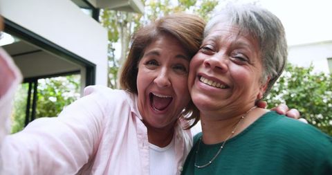 Joyful Mother and Daughter Taking Selfie in Backyard