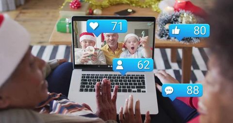 Couple video calling family for christmas with social media reactions and holiday decor