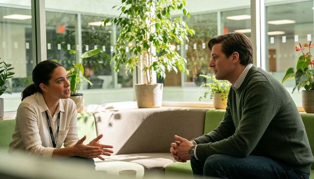 Two coworkers having focused conversation and planning in modern office lounge with natural light
