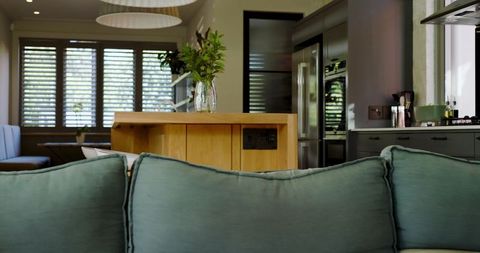 Contemporary living room with teal couch and stylish kitchen