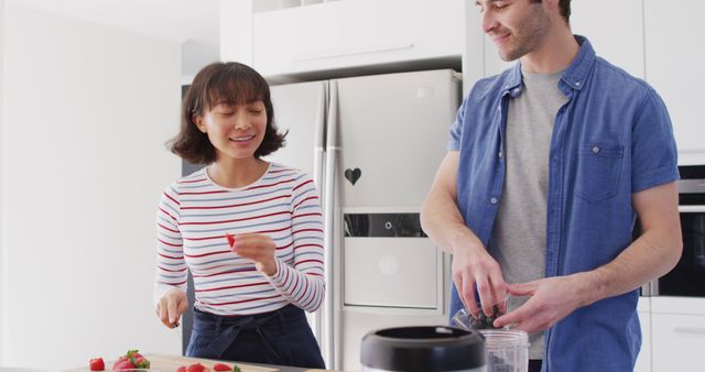 Image of happy diverse couple preparing meal together in kitchen. Love, relationship and spending quality time together concept.