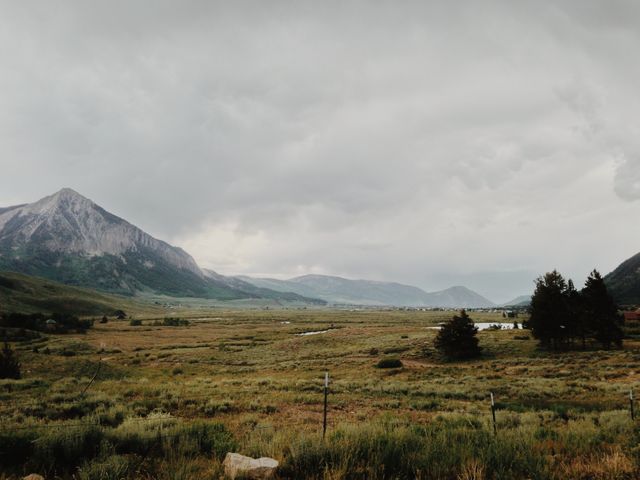 This image captures a broad view of a tranquil valley with a range of mountains in the background under a cloudy sky. Ideal for use in travel blog posts, environmental campaigns, posters promoting outdoor activities, and websites or articles focused on nature and landscapes.