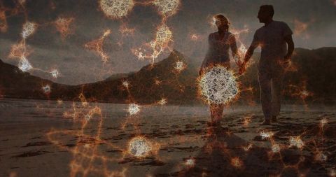 Couple Walking at Dusk with Magical Light Particles by the Seaside