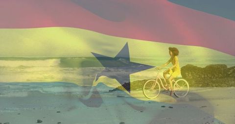 Sunlit woman riding bicycle along windblown beach with flag overlay double exposure