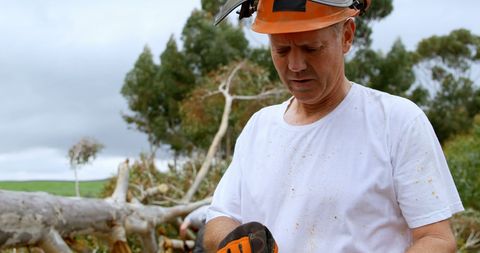 Carpenter in Safety Gear Preparing Chainsaw in Forest - Download Free Stock Images Pikwizard.com