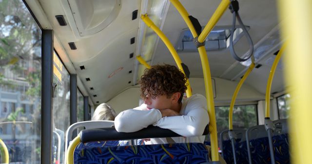 Thoughtful biracial man sitting in city bus looking through window - Download Free Stock Photos Pikwizard.com