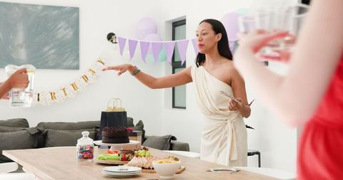 Women preparing table for indoor birthday celebration