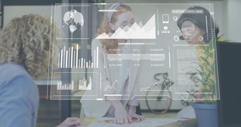 Women collaborating over plans with augmented analytics dashboards in modern workspace