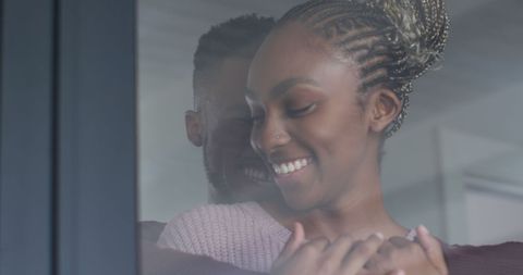 Happy African American Couple Embracing by Window in Natural Light